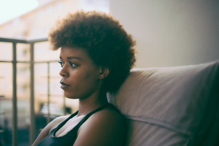 Jeune femme noire assise sur un divan