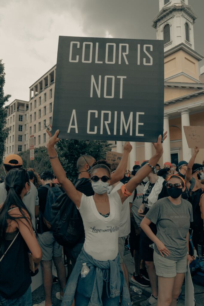 Femme tenant une affiche Color is not a crime dans une manifestation