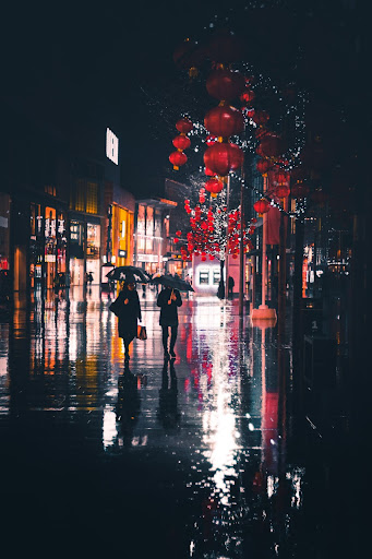 2 personnes sous un parapluie la nuit