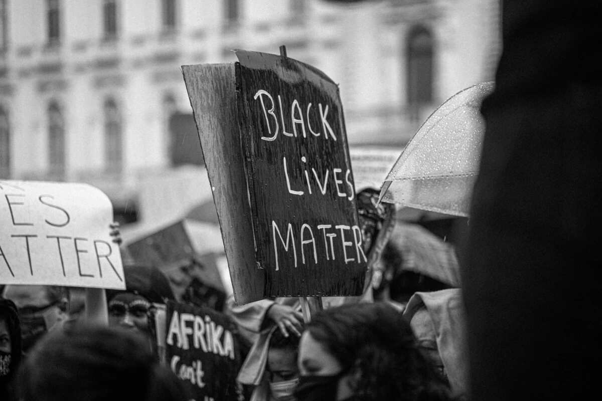 Manifestation avec une affiche Black Lives Matter en noir et blanc